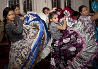 Na zdjęciu pięć dziewczynek w warkoczach i długich, romskich sukniach z falbanami, unoszonych w trakcie tańca. Są w sali, za nimi okna z kratownicą.